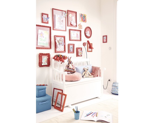 Kinderkamer met bankkist, gedecoreerd met fotolijsten en speelgoed