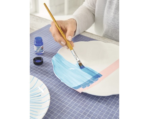 Decoratie van een bord met penseel en verf