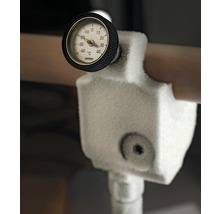 Detailopname van een bevroren temperatuurmeter op een pijpleiding
