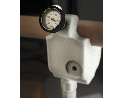 Detailopname van een bevroren temperatuurmeter op een pijpleiding