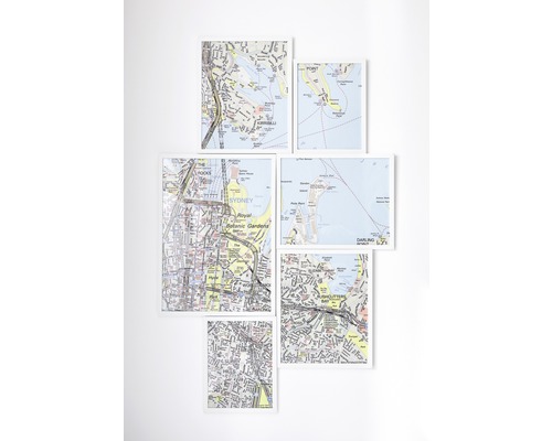 Meerdere ingelijste kaarten van Sydney, Australië, zijn aan een muur bevestigd.