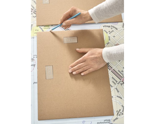 Persoon tekent met een potlood op een stuk karton.