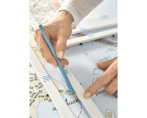 Een persoon die met een potlood een lijn trekt op een zeekaart