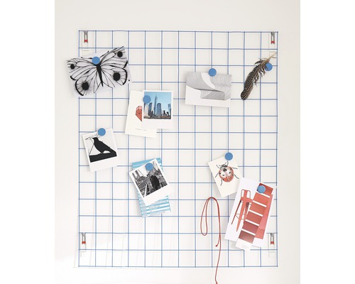 Draadroosterbord met notities en decoraties bevestigd met magneten