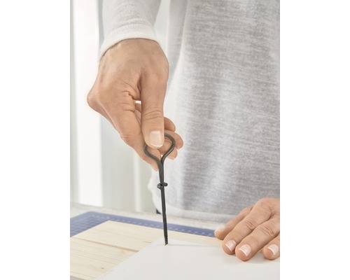 Persoon die met een priem een gat in papier prikt