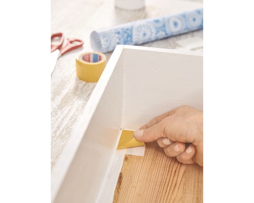 Afplakband aanbrengen op een wit frame