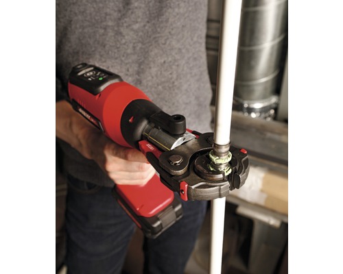 Een persoon gebruikt een accupersgereedschap om een pijpverbinding te maken.