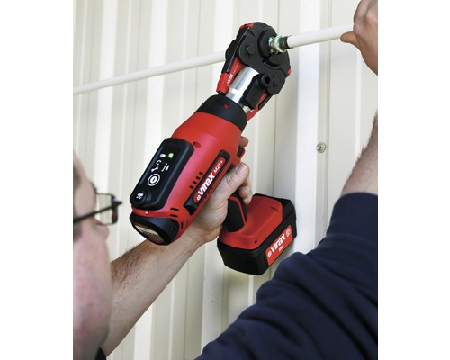 Een persoon gebruikt een accu-aangedreven perstang om een pijpleiding te persen.