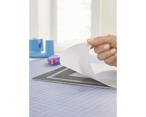 Hand die beschermfolie van een snijmat verwijdert