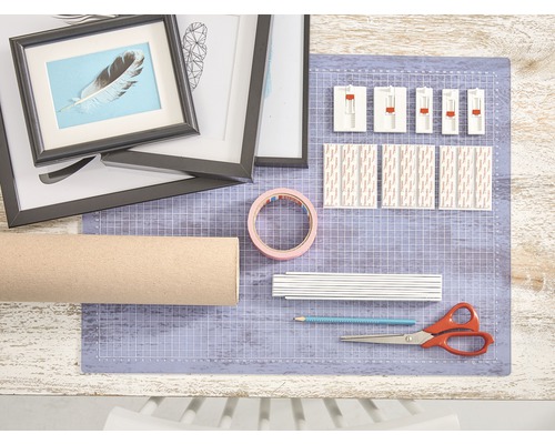 Knutseltafel met fotolijsten, kartonnen rol, plakband, schaar, potlood en plakstrips