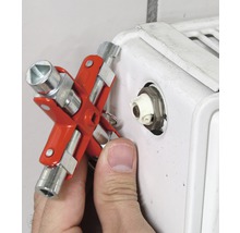 Een man gebruikt een radiateursleutel op een radiator.