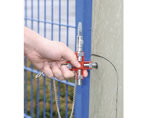 Een hand bedient een moersleutel op een metalen paal