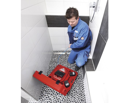 Een man gebruikt een inspectiecamera in een badkamer om afvalwaterleidingen te inspecteren.