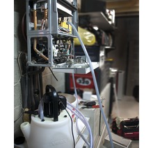 Geopende verwarmingsketel wordt gereinigd met een spoelpomp.