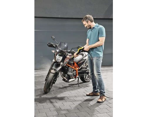 Man reinigt motorfiets met hogedrukreiniger