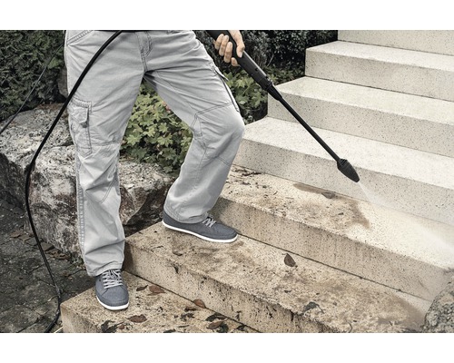 Persoon reinigt trap met hogedrukreiniger
