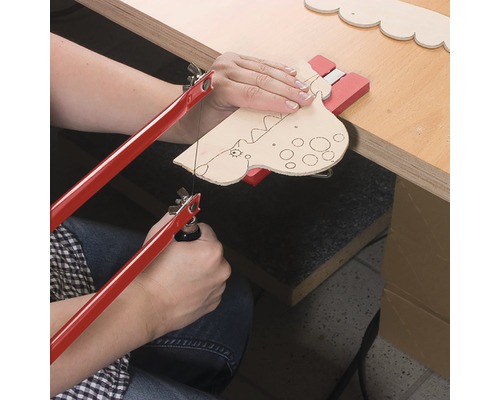 Persoon zaagt dinosaurusvorm met figuurzaag