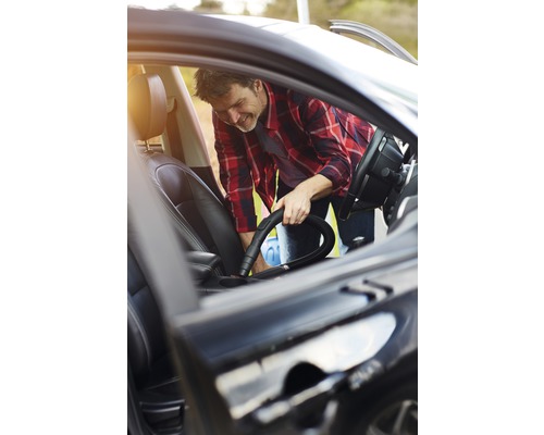 Man maakt auto schoon met stofzuiger