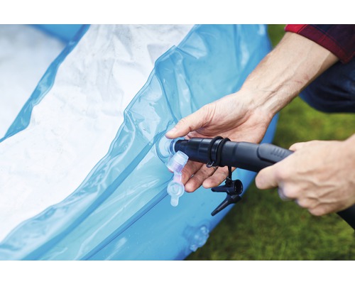 Een persoon pompt een zwembad op.