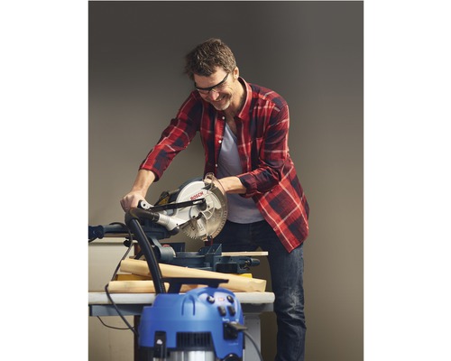 Man zaagt hout met een verstekzaag en gebruikt een stofzuiger voor de reiniging.