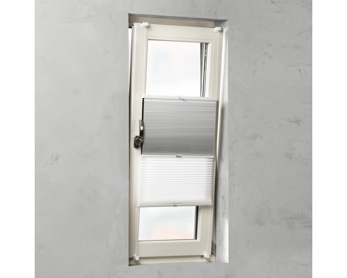 Raam met grijs en wit plisségordijn