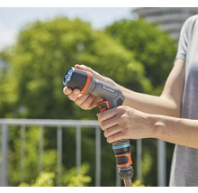 Een persoon houdt een Gardena multispuit vast.