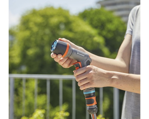 Een persoon houdt een Gardena multispuit vast.