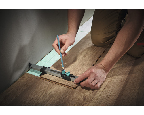 Persoon markeert laminaat met potlood en aftekeninstrument voor laminaat