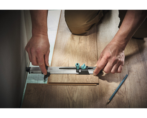 Persoon gebruikt een meetinstrument om een stuk laminaat te meten