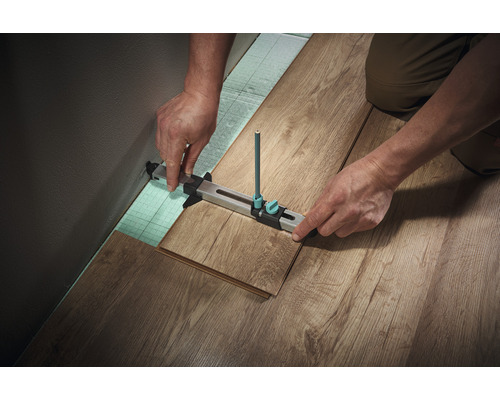 Timmerlieden die een laminaatvloer leggen met een snijgereedschap