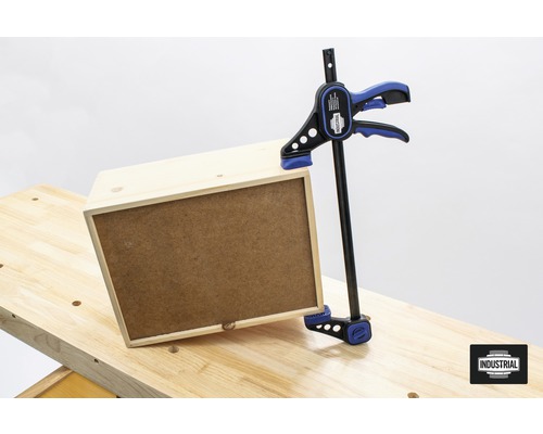 Houten kist wordt met een éénhandsklem op een werkbank bevestigd