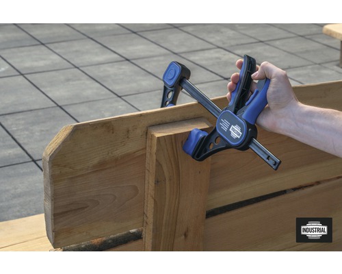 Persoon gebruikt eenhandsklem om hout te lijmen