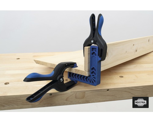 Twee werkstukklemmen fixeren houten stukken op een werkbank