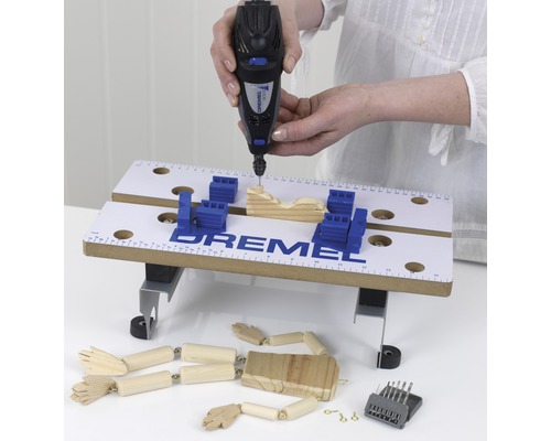 Dremel multifunctioneel gereedschap in gebruik met werkstuk en accessoires op een werkbank