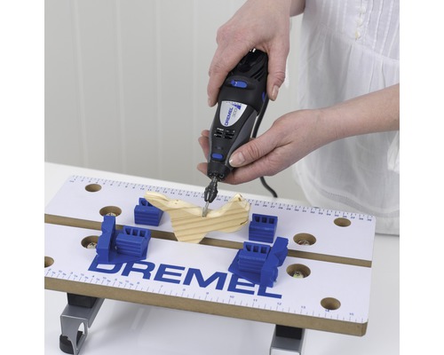 Dremel logo, multifunctioneel gereedschap in gebruik op werkbank