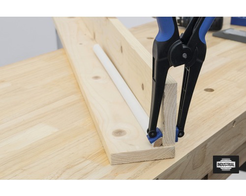 Houten latten met éénhandsklem en ronde staaf op een werkbank