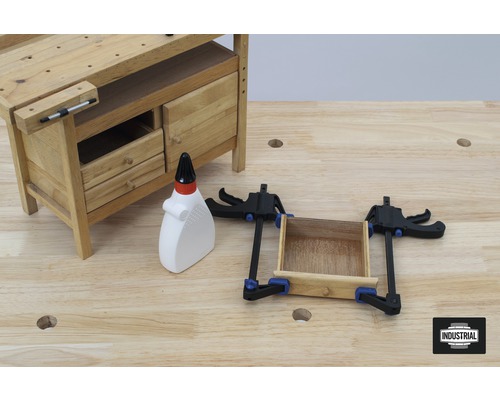 Werkbank met laden, houtlijm en klemmen op een houten oppervlak