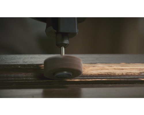 Een schuurschijf op een houten werkstuk.