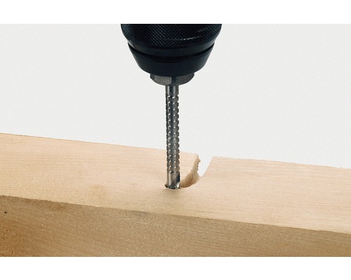 Een boormachine boort een gat in een stuk hout.