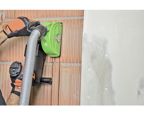 Een muurfrees in gebruik op een bakstenen muur met aangrenzende gipsplaat