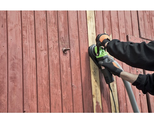 Iemand schuurt een houten deur met een wand schuurmachine.
