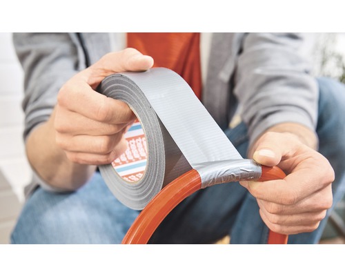 Persoon repareert een slang met ducttape