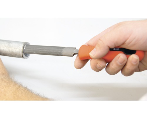 Een hand gebruikt een sleutelvijl om een pijp te ontbramen.