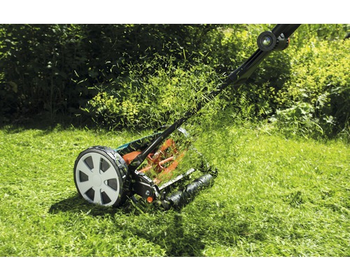 Handmatige grasmaaier tijdens het grasmaaien in de tuin