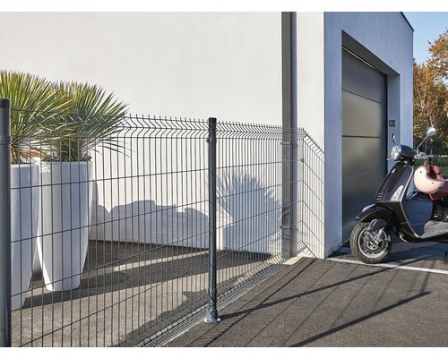 Draadhek met aangrenzend woonhuis en scooter