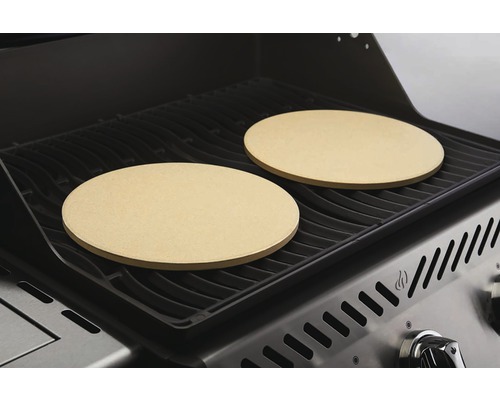 Twee ronde pizzastenen op een grillrooster