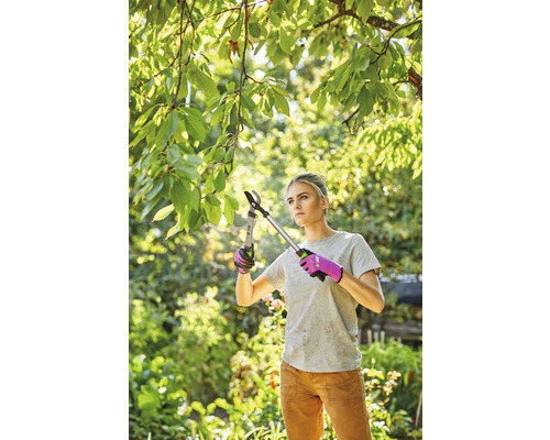 Vrouw snoeit takken met een takkenschaar in de tuin