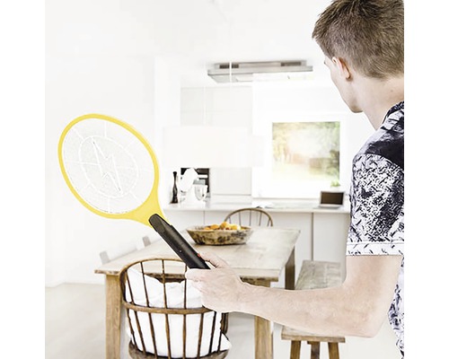 Man gebruikt elektrische vliegenmepper in lichte keuken.