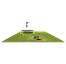Gazon met trampoline, springend persoon en robotmaaier.