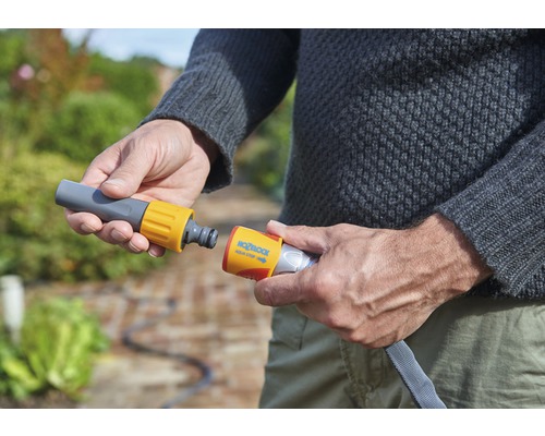 Een persoon verbindt een tuinslang met een slangconnector.